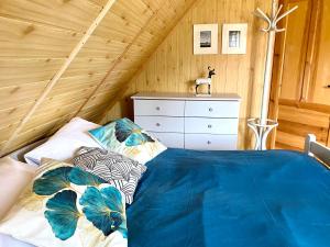a bedroom with a bed and a dresser at Amalka Wita in Sulęczyno