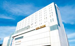 um edifício branco com uma placa no topo em Odakyu Hotel Century Sagami Ono em Sagamihara