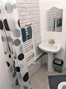 a white bathroom with a sink and a mirror at Casa Agape in Piteşti