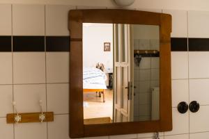 a mirror in a bathroom with a bed in a room at Penzion Berdina in Suchá Loz