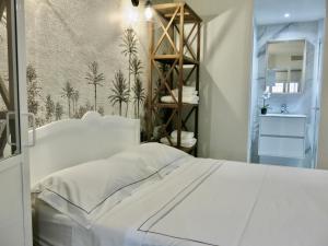 a bedroom with a white bed and a bathroom at Les Petits Volets 3 appartements au choix in Antibes