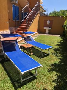 a row of blue bleachers in front of a house at Sunflower Guest House in Carrara