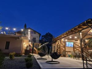 a house with two chairs in a courtyard at night at Pensiunea Lotus Corbu in Corbu