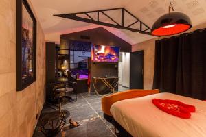 sypialnia z łóżkiem i telewizorem w pokoju w obiekcie Loft Room 85, petite maison avec jacuzzi privatif w mieście Les Sables-dʼOlonne