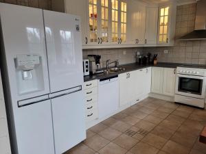 una cocina con electrodomésticos blancos y armarios blancos en Flohytta, en Stryn