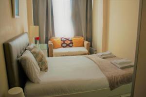 a bedroom with a bed and a chair and a window at Apartamento Familiar em Zona Histórica de Lisboa in Lisbon