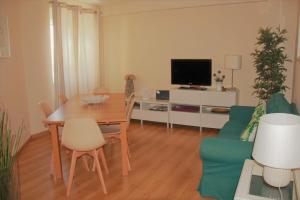 a living room with a table and a tv at Apartamento Familiar em Zona Histórica de Lisboa in Lisbon