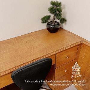 a desk with a potted plant on top of it at บ้านเกื้อ เดอะ ลิฟวิ่ง in Nakhon Ratchasima