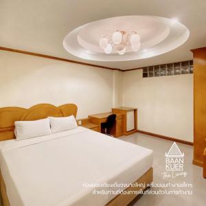 - une chambre avec un lit et un ventilateur de plafond dans l'établissement บ้านเกื้อ เดอะ ลิฟวิ่ง, à Nakhon Ratchasima