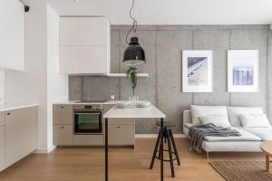 una cucina e un soggiorno con divano e tavolo di S35 Apartments Gdynia Orłowo a Gdynia
