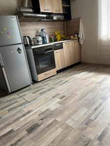 una cucina con elettrodomestici in acciaio inossidabile e pavimenti in legno di Вила Никови a Durankulak