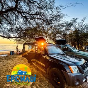 un camión estacionado en la playa con el sol brillando en él en Epic Maui Car Camping en Kahului