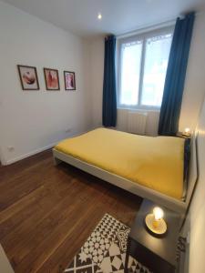 - une chambre avec un lit jaune et une fenêtre dans l'établissement Appartement hyper centre de Montargis, à Montargis