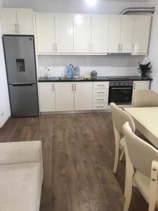 a kitchen with white cabinets and a black refrigerator at Borsh Beach Apartments - BBA in Borsh