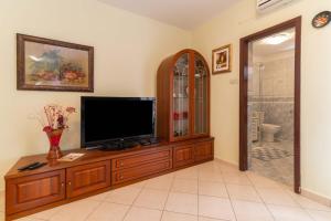 a living room with a television on a wooden entertainment center at House Suzi in Zadar