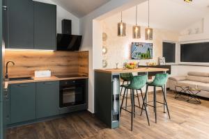 una cucina con sedie verdi e un tavolo in una stanza di Apartment 88 - Rooftop jacuzzi & terrace a Zara (Zadar)