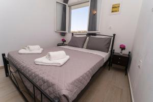 1 dormitorio con 1 cama con toallas en Mano's House, en Triopetra