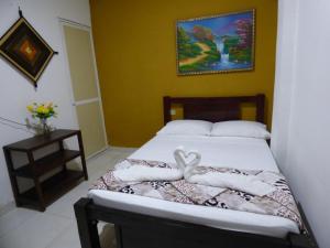 a bedroom with a bed with towels on it at Hostal Alto de la Montaña in Minca