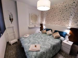 1 dormitorio con 1 cama con papel pintado de flores en Duplex con vistas al Picu Pienzu, Colunga, en Colunga