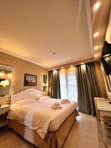 a bedroom with a large bed and a large window at Anemolia Resort and Spa in Ioannina