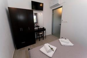 una stanza con un armadio nero e un tavolo con asciugamani bianchi di Mano's House a Triopetra