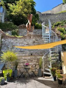 a patio with a stone wall with a yellow ribbon at Mademoiselle Citadelle in Namur
