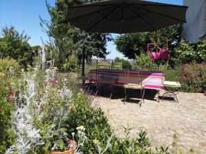 a bench and an umbrella in a garden at Demeure de BoisClaireau in Le Mans +28 photos
