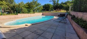 una piscina con una silla y un patio en Le Domaine du Bien-Être en Rahon