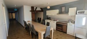 a kitchen with a long wooden table and chairs at Le Domaine du Bien-Être in Rahon