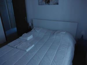 - un lit blanc avec des draps blancs dans une chambre dans l'établissement Le viroulet, à Valdeblore