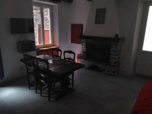 a dining room with a table and chairs and a fireplace at Le viroulet in Valdeblore