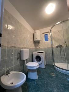 een badkamer met toilet, wastafel en wasmachine bij Sea view apartment Poreč in Poreč +12 foto's