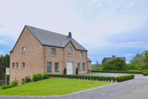 a brick house with a lawn in front of it at B&B Maison Durbois in Durbuy