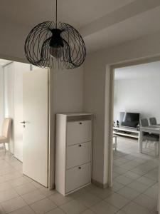 een woonkamer met een kroonluchter en een dressoir bij T2 Port Marianne avec balcon et place de parking in Montpellier