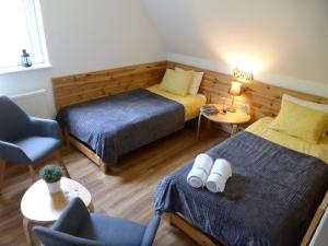 a hotel room with two beds and a chair at Zającówka in Polanica-Zdrój