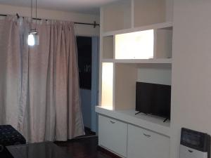 メンドーサにあるDepartamento ciudad de Mendozaのリビングルーム(白い棚に薄型テレビ付)
