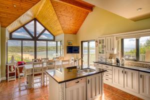 a kitchen with white cabinets and a large window at Fintra Beach B&B in Donegal