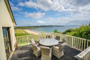a table and chairs on a deck with a view of the ocean at Fintra Beach B&B in Donegal