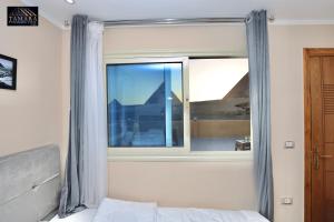 a bedroom with a large window and a bed at Tamara Pyramids View in Cairo