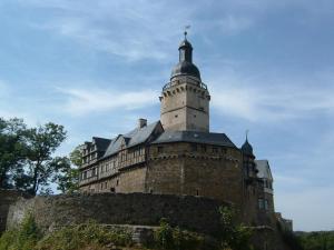 un viejo castillo con una torre encima en Ferienpark Rosstrappe en Thale