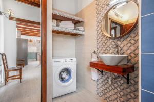 een badkamer met een wasmachine en een wastafel bij Casa Flora in Villaverde
