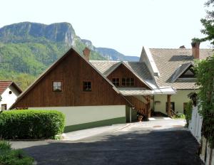 une grande maison en bois avec des montagnes en arrière-plan dans l'établissement Apartments Torkar, à Bled