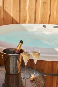 Duas taças de champanhe e um balde com banheira. em Waters Edge Retreat em Naseby