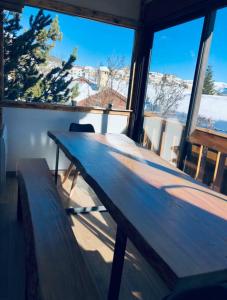 a wooden bench sitting in a room with windows at Chalet 8 couchages à 100m du bas des pistes et commerces in Les Angles