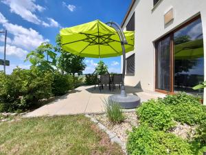 un patio con una mesa y una sombrilla amarilla en apartmán U Rané BOBULE en Znojmo