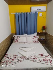 a bed in a room with a blue curtain at Casa Goio Morro de São Paulo in Morro de São Paulo