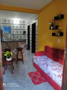 a living room with a red couch and a fireplace at Casa Goio Morro de São Paulo in Morro de São Paulo