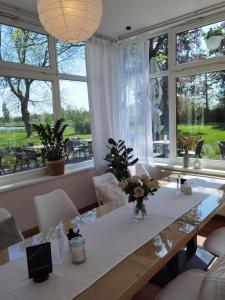 a dining room with a table and some windows at Stedinger Landhotel & Café in Berne