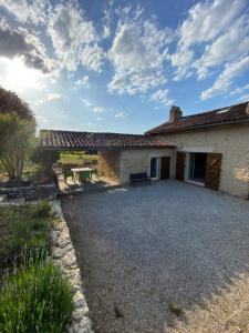 une maison avec une allée en gravier en face de celle-ci dans l'établissement Maison en pierre à la campagne en Périgord Dordogne, à Saint-Germain-du-Salembre