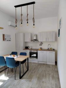 a kitchen with a wooden table and blue chairs at Apartment MAIO in Viskovo